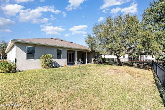 rear view of house featuring a lawn