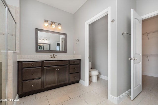 bathroom with walk in shower, vanity, toilet, and tile patterned flooring