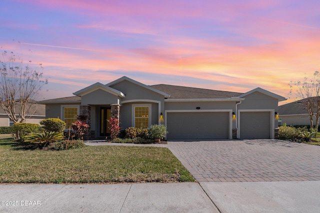 single story home featuring a garage and a yard