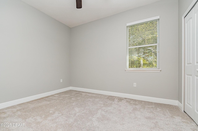 carpeted spare room featuring ceiling fan