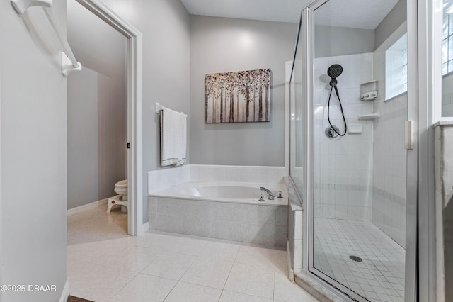 bathroom with a garden tub, toilet, a shower stall, tile patterned flooring, and baseboards