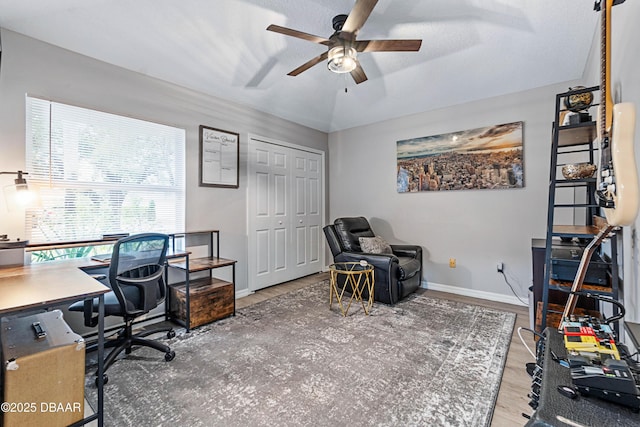 office space with lofted ceiling, a ceiling fan, baseboards, and wood finished floors