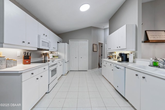 kitchen featuring light tile patterned flooring, white appliances, white cabinets, vaulted ceiling, and light countertops