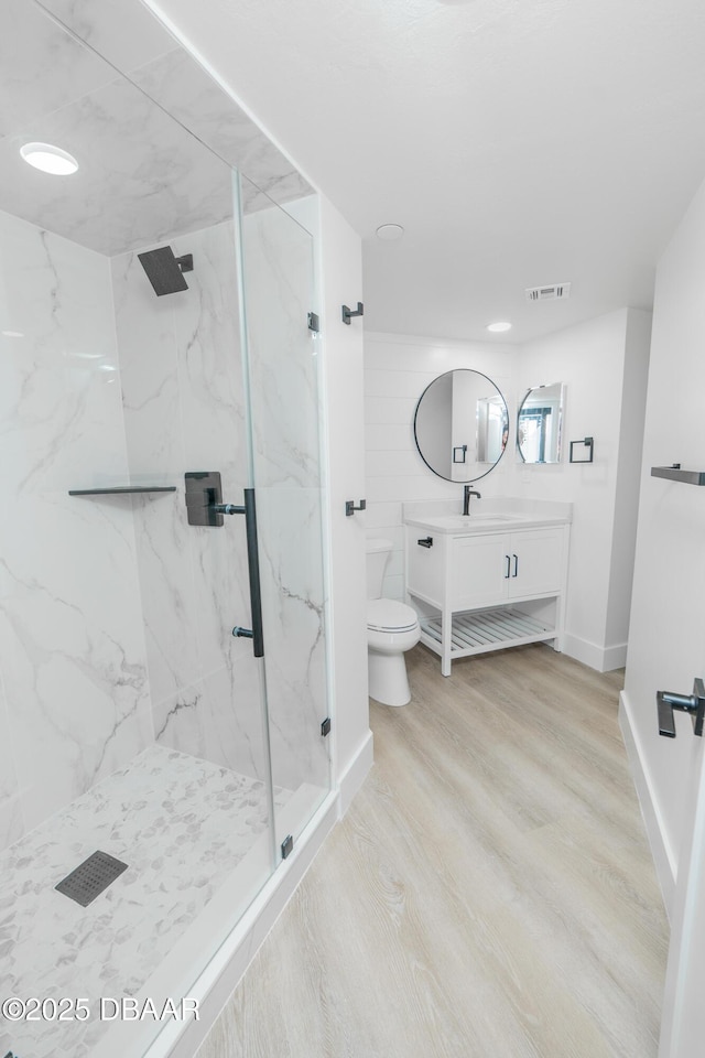 bathroom with hardwood / wood-style flooring, vanity, toilet, and an enclosed shower