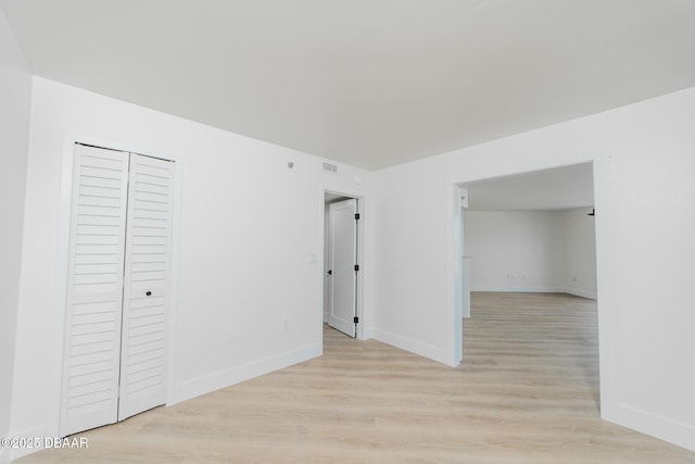 unfurnished bedroom featuring a closet and light hardwood / wood-style flooring