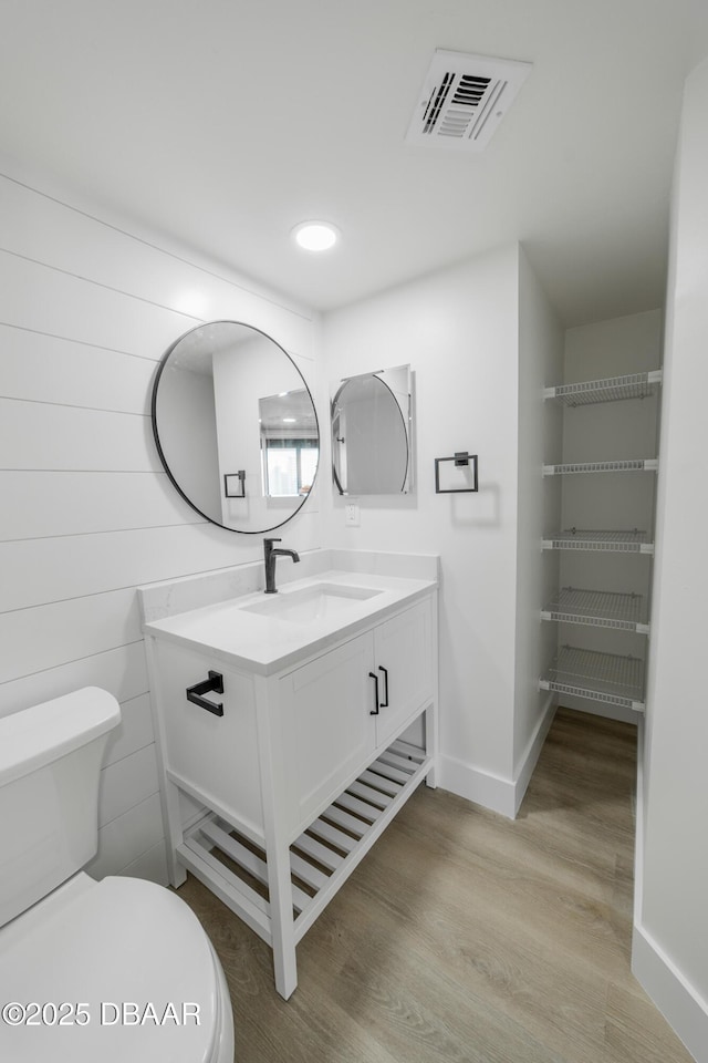 bathroom featuring vanity, toilet, and hardwood / wood-style floors