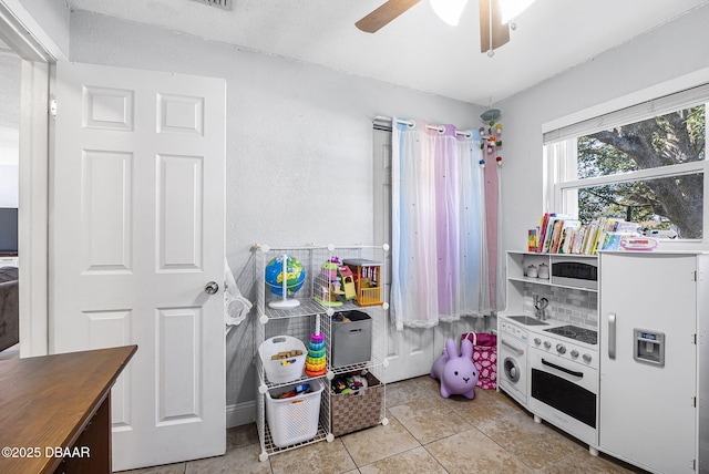 game room featuring a ceiling fan and light tile patterned flooring