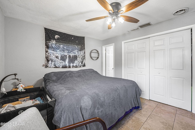 bedroom with a closet, visible vents, ceiling fan, and a textured ceiling