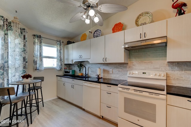 kitchen with sink, light hardwood / wood-style flooring, vaulted ceiling, white appliances, and decorative backsplash