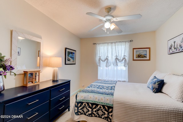 carpeted bedroom with ceiling fan and a textured ceiling