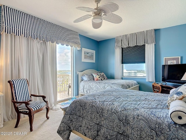 bedroom with a textured ceiling, access to outside, carpet floors, and a ceiling fan