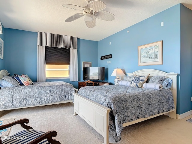 carpeted bedroom with ceiling fan, a textured ceiling, and baseboards