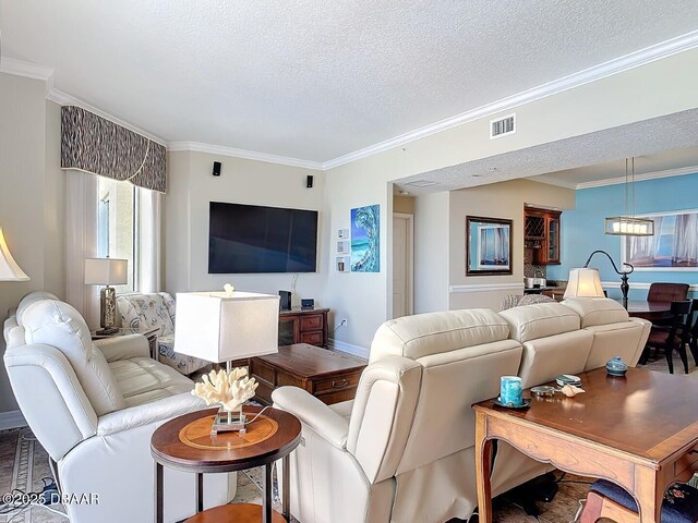 living room with a textured ceiling, visible vents, and crown molding