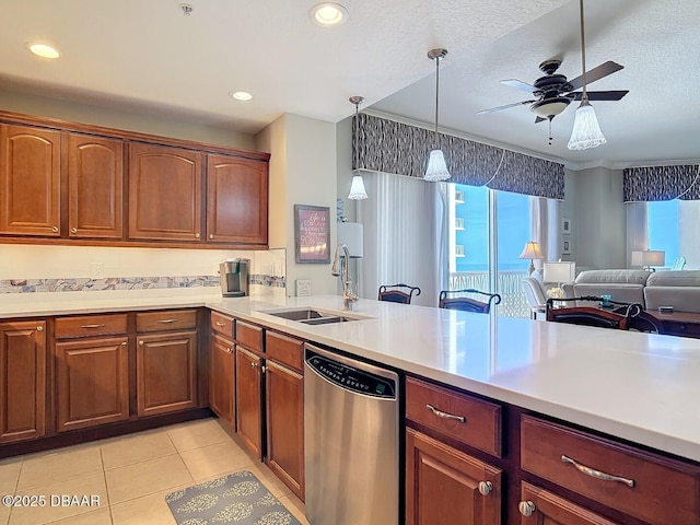 kitchen featuring light countertops, stainless steel dishwasher, open floor plan, light tile patterned flooring, and a sink