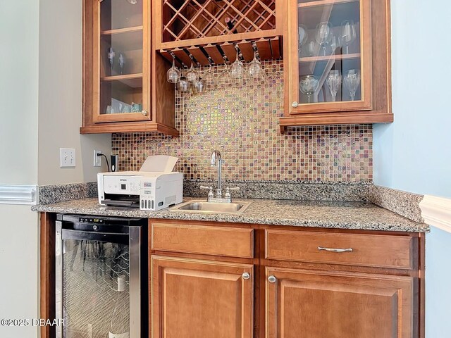 bar with beverage cooler, decorative backsplash, a sink, and wet bar