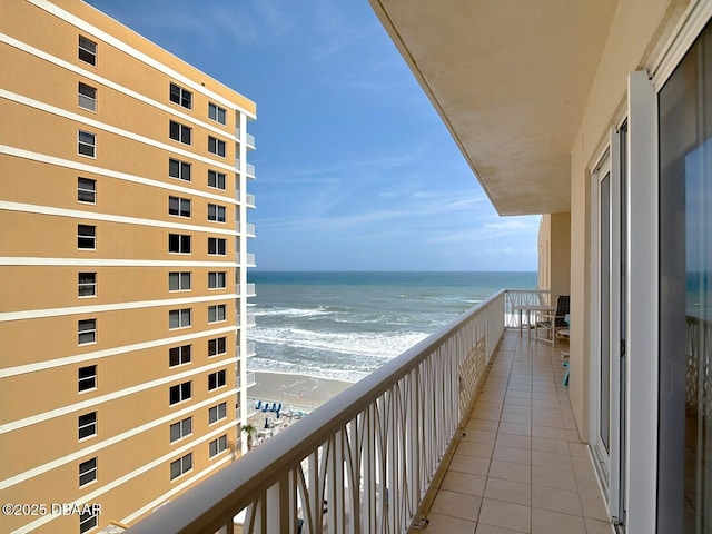 balcony with a water view and a beach view