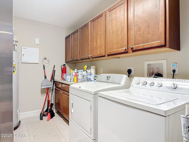 laundry area with cabinet space, baseboards, washer and dryer, and light tile patterned flooring