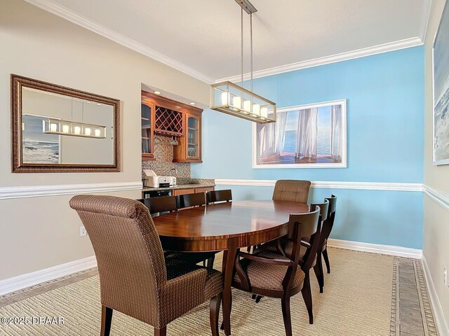 dining space featuring baseboards and crown molding