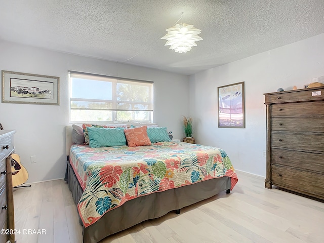 bedroom featuring light wood-type flooring and a textured ceiling