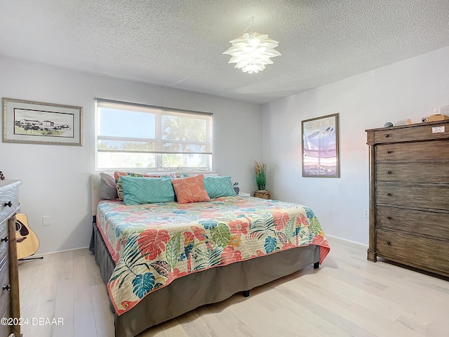1510 Ocean Shore Blvd Unit 406, Ormond Beach, FL 32176 - bedroom with a textured ceiling, light wood finished floors, and baseboards