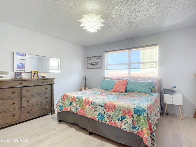 bedroom featuring a textured ceiling and light wood-type flooring