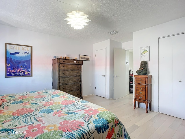 1510 Ocean Shore Blvd Unit 406, Ormond Beach, FL 32176 - bedroom with light wood-style floors, a textured ceiling, and a closet