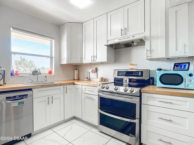 1510 Ocean Shore Blvd Unit 406, Ormond Beach, FL 32176 - kitchen with appliances with stainless steel finishes, under cabinet range hood, wooden counters, and light marble finish floors