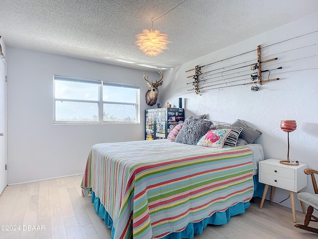 bedroom featuring a textured ceiling and hardwood / wood-style flooring