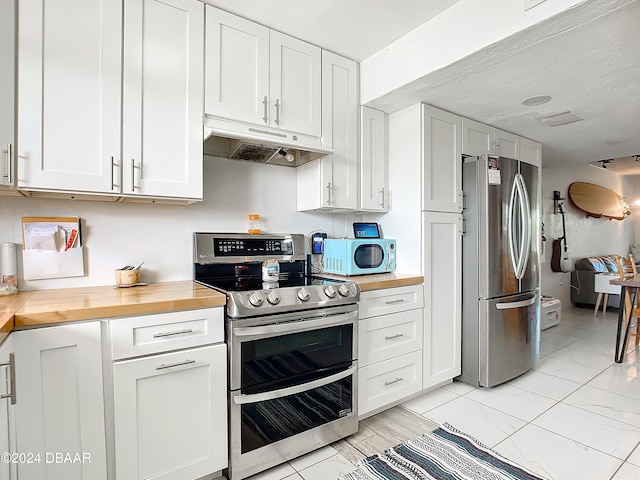 kitchen featuring white cabinetry, appliances with stainless steel finishes, and wood counters