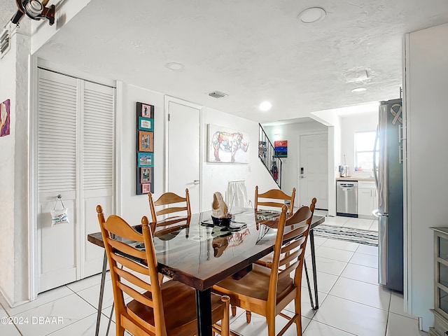 tiled dining space with a textured ceiling