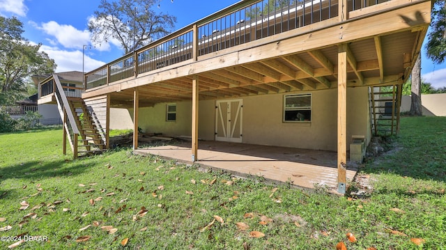 rear view of house with a lawn, a patio area, and a wooden deck