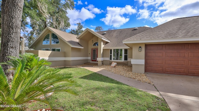 ranch-style home featuring a garage and a front lawn