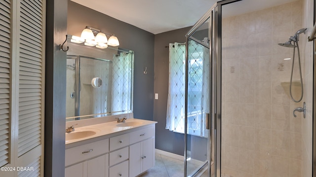 bathroom with tile patterned floors, a shower with door, and vanity