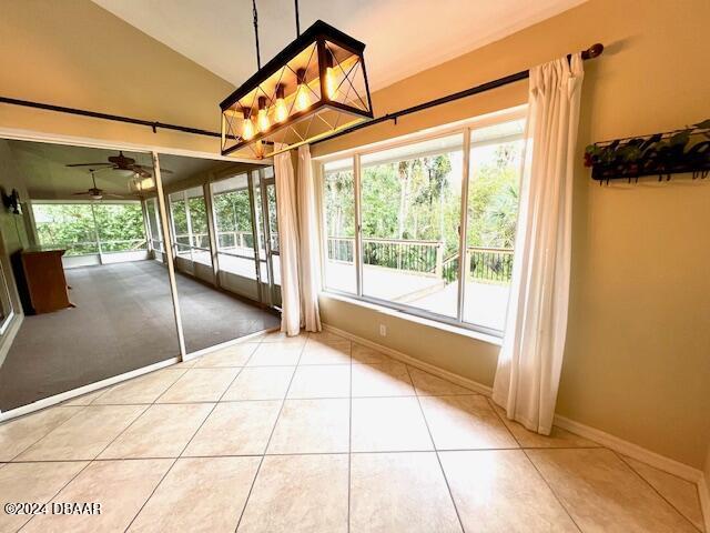 entrance foyer with french doors, sink, high vaulted ceiling, light tile patterned flooring, and ceiling fan with notable chandelier