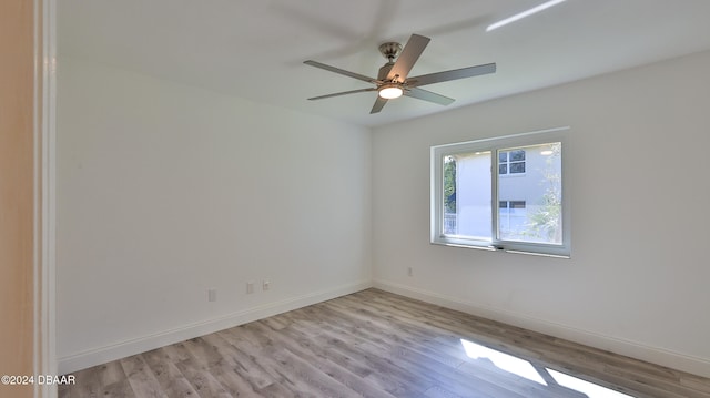 empty room with ceiling fan and light hardwood / wood-style flooring