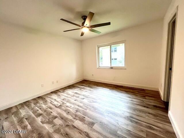 spare room featuring ceiling fan and dark wood-type flooring