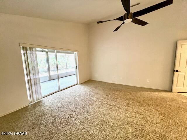 unfurnished room with ceiling fan and carpet