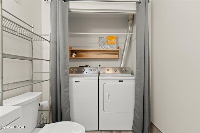 washroom featuring washing machine and clothes dryer and hardwood / wood-style flooring