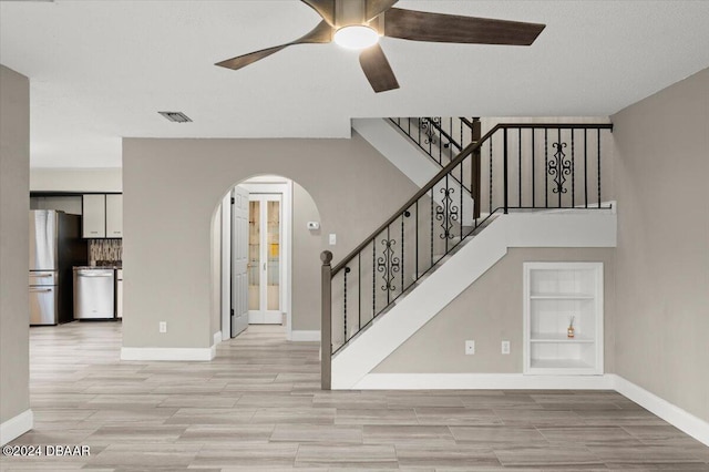 stairs featuring built in shelves, wood-type flooring, and ceiling fan