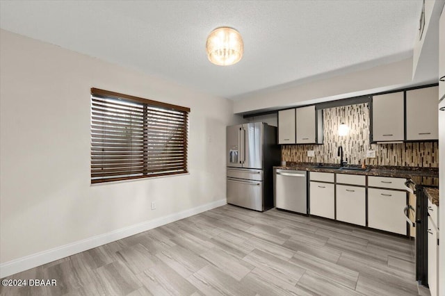 kitchen featuring a textured ceiling, sink, appliances with stainless steel finishes, and tasteful backsplash