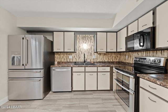 kitchen featuring stainless steel appliances, a textured ceiling, sink, tasteful backsplash, and white cabinetry