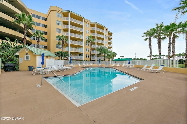 view of pool with an outbuilding, a patio, and grilling area