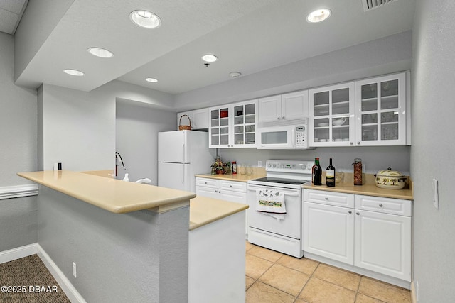 kitchen featuring kitchen peninsula, light tile patterned floors, white cabinets, and white appliances