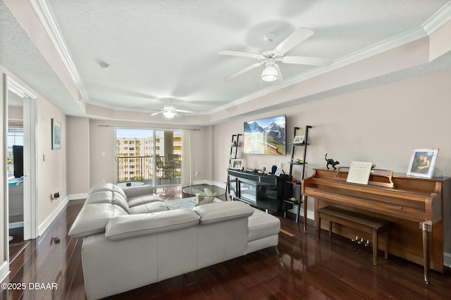 living room featuring crown molding, dark hardwood / wood-style floors, ceiling fan, a textured ceiling, and a tray ceiling