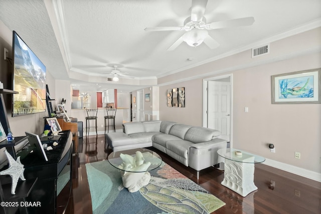 living room featuring a textured ceiling, a tray ceiling, dark hardwood / wood-style floors, and crown molding