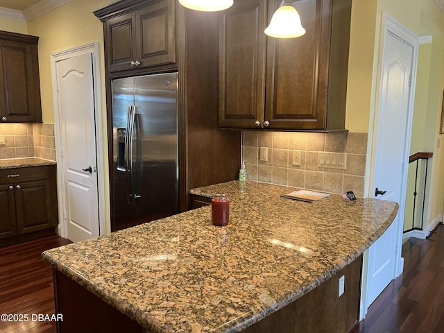 5090 Riverside Dr Unit 108, Port Orange, FL 32127 - kitchen with stainless steel refrigerator with ice dispenser, dark wood-style flooring, crown molding, dark brown cabinetry, and light stone countertops