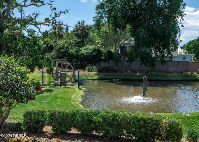 surrounding community with a lawn and a water view