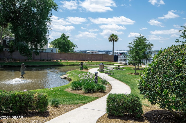 surrounding community featuring a lawn and a water view