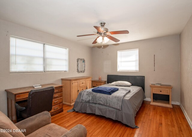 bedroom featuring multiple windows, light hardwood / wood-style flooring, and ceiling fan