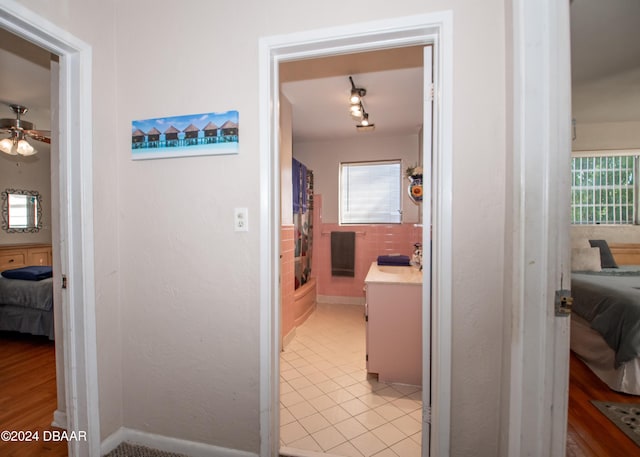 hallway with light tile patterned floors and a healthy amount of sunlight